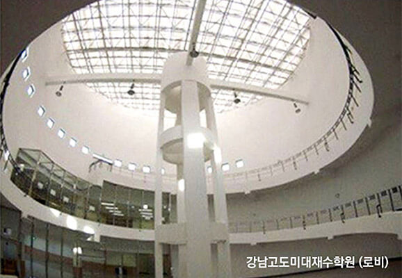 강남고도미대재수학원 로비, 가운데 기둥과 그 위로 커다란 원형 천장으로 밝은 햇빛이 들어오고 있다.